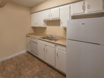 Houston apartment for rent - a kitchen with white cabinets and a refrigerator