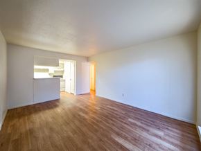 Houston apartment for rent - the living room and kitchen of an empty house with wood floors