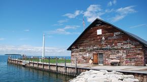 Sister Bay apartment for rent - an old building on the dock of a pier with the water