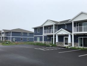 Sister Bay apartment for rent - a row of blue houses with balconies and a parking lot