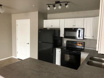 Sister Bay apartment for rent - a kitchen with black appliances and white cabinets