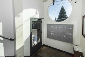 Oakland apartment for rent - A round window with a view of a tree and a sky.