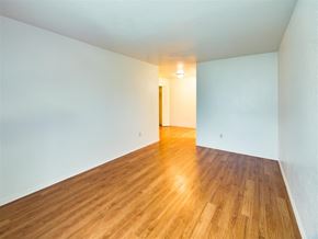 Houston apartment for rent - an empty living room with wood floors and white walls