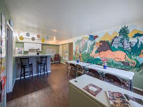 Houston apartment for rent - a dining room with tables and chairs and a mural on the wall