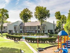 Houston apartment for rent - a park with a playground and a pool in front of an apartment building