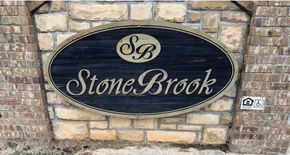 Stilwell apartment for rent - a sign for stone brook on a brick wall
