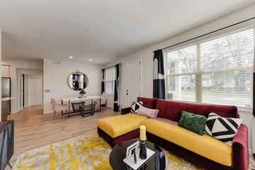 Morgan Hill apartment for rent - Living room with red and yellow couch and Harwood inspired flooring.  Dining area in the distance.
