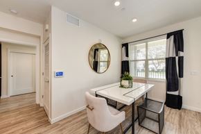 Morgan Hill apartment for rent - Dining area with table, chairs and potted plant on the table.  Large window with curtains overlooking the entrance at Morgan Ranch Apartments, Morgan Hill