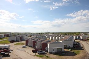 Thompson apartment for rent - A sunny day in a residential area with houses and cars.
