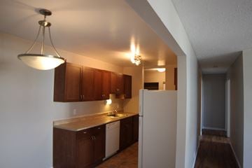 Thompson apartment for rent - A kitchen with brown cabinets and a white refrigerator.