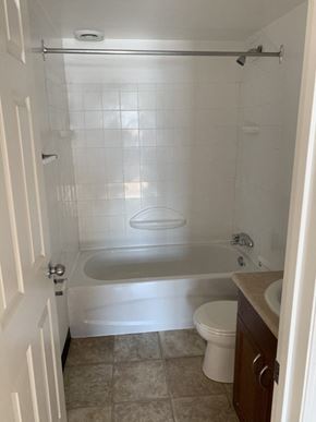 Thompson apartment for rent - A white bathroom with a toilet, sink, and bathtub.