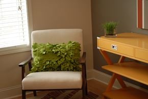 Durham apartment for rent - a chair with a green pillow in a room with a desk