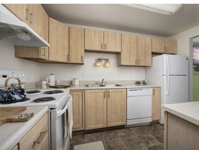 Gladstone apartment for rent - A kitchen with wooden cabinets and white appliances.
