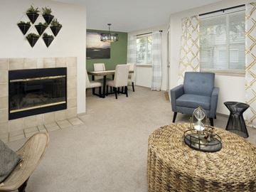 Gladstone apartment for rent - A living room with a fireplace, a chair, a table, and a painting on the wall.