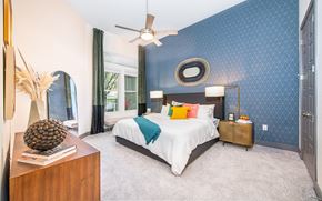 Frisco apartment for rent - a blue and white bedroom with a bed and a ceiling fan