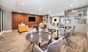 Frisco apartment for rent - a lounge area with tables and chairs and a television
