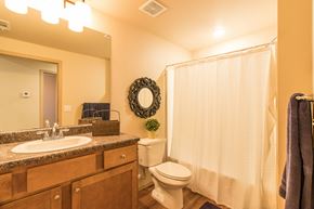Gentry apartment for rent - a bathroom with a shower toilet and sink and a mirror