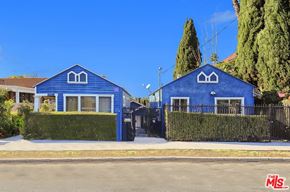 Los Angeles apartment for rent - A blue house with a black fence and a green hedge in front.