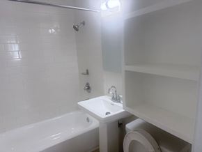 Los Angeles apartment for rent - A white bathroom with a tub, sink, and toilet.