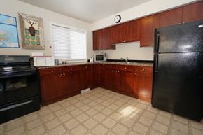 Wainwright apartment for rent - a kitchen with black appliances and wooden cabinets