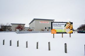 Wainwright apartment for rent - a sign in the snow in front of a building