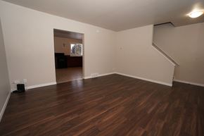 Wainwright apartment for rent - an empty living room with hard wood floors and white walls