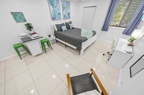 Miami apartment for rent - a bedroom with a bed and a desk in a small room