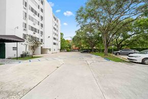 Miami apartment for rent - an empty parking lot with a white building on the side of it