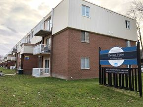 Sarnia apartment for rent - an apartment building with a sign in front of a gate