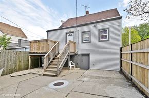 Chicago apartment for rent - a gray house with a yard and a deck
