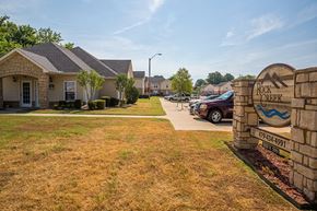 Fort Smith apartment for rent - a sign in front of a house with cars parked in a driveway