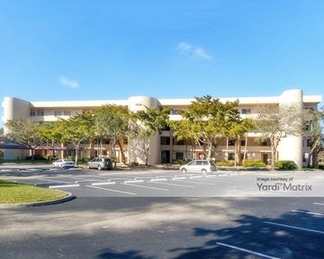 Lauderhill apartment for rent - A parking lot in front of a building with cars parked.