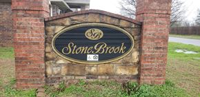 Durant apartment for rent - a stone brick sign in front of a building