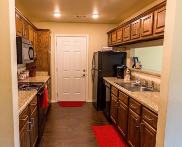 Durant apartment for rent - a kitchen with wooden cabinets and a black refrigerator