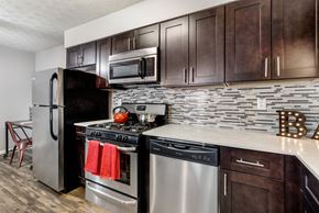 Columbus apartment for rent - A kitchen with dark brown cabinets and a white countertop.