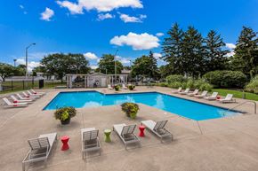 Columbus apartment for rent - A pool surrounded by lawn chairs and trees.