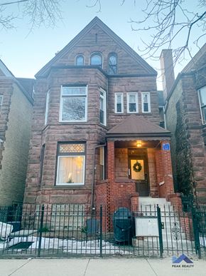 Chicago apartment for rent - a brick house with a fence in front of it