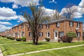 Detroit apartment for rent - a row of brick apartment buildings with grass and trees