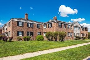 Detroit apartment for rent - the front of a brick apartment building with grass and a sidewalk