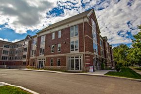 Rochester apartment for rent - a large brick building with a cloudy sky in the background