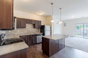 Murrysville apartment for rent - A kitchen with dark wood cabinets and granite countertops.