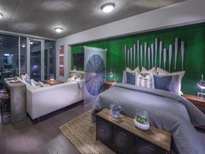 Houston apartment for rent - A bedroom with a bed, a couch, and a wall art.