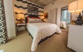 Houston apartment for rent - A bedroom with a large bed and a painting on the wall.