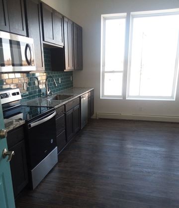 Saint Paul apartment for rent - an empty kitchen with black appliances and wood floors