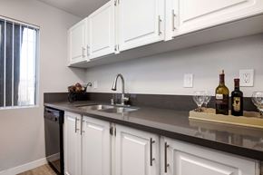 Palmdale apartment for rent - a kitchen with white cabinets and a sink and a window