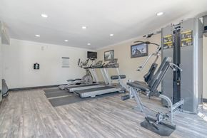 Palm Springs apartment for rent - a gym with treadmills and weights in the corner of a room