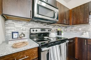 Upper St Clair apartment for rent - a kitchen with a stove and microwave and wooden cabinets