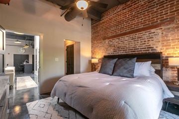 Porterdale apartment for rent - A bedroom with a large bed and a brick wall.