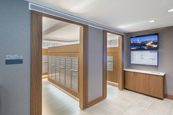 A modern office lobby with a tv screen and a row of filing cabinets.