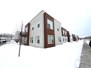 Madison apartment for rent - Apartment building with snow on the ground and trees in the background.